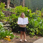 child holding up south australian travel journal at a sink hole
