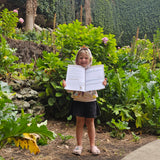 child holding up south australian travel journal at a sink hole