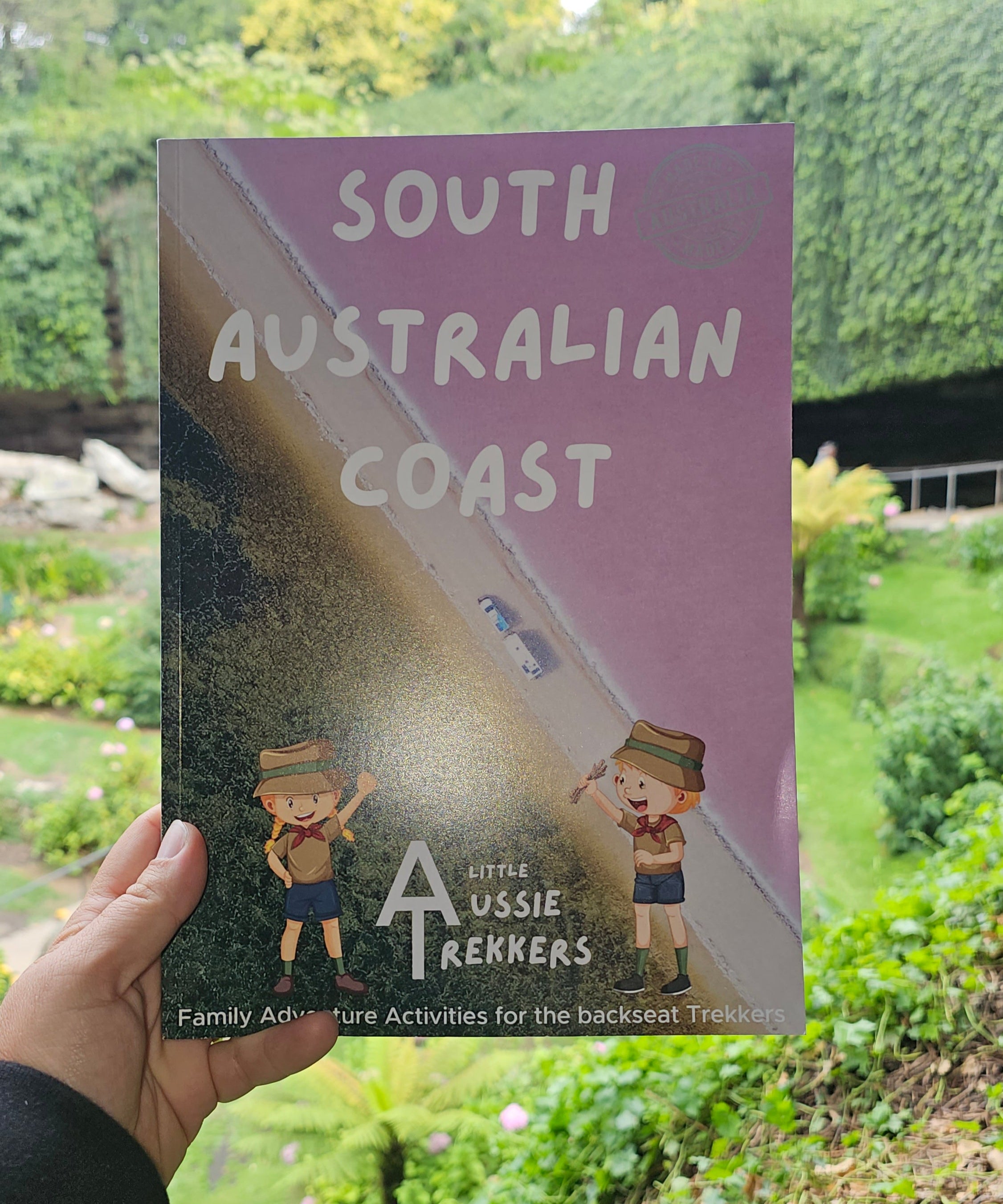 South Australian Coast journal held up against garden sink hole