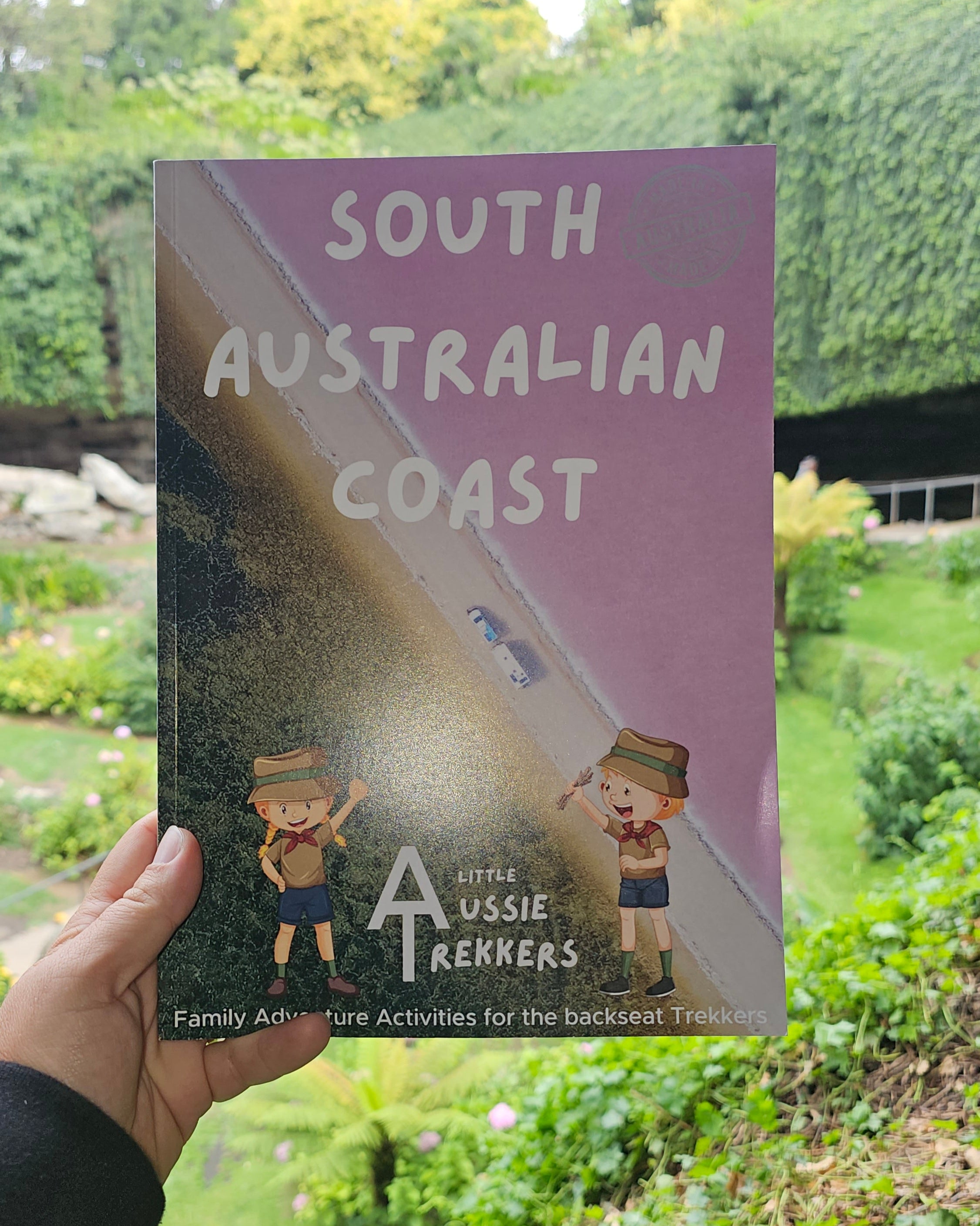 South Australian Coast journal held up against garden sink hole