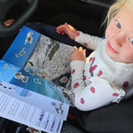Child in a car seat with a south australian travel journal 