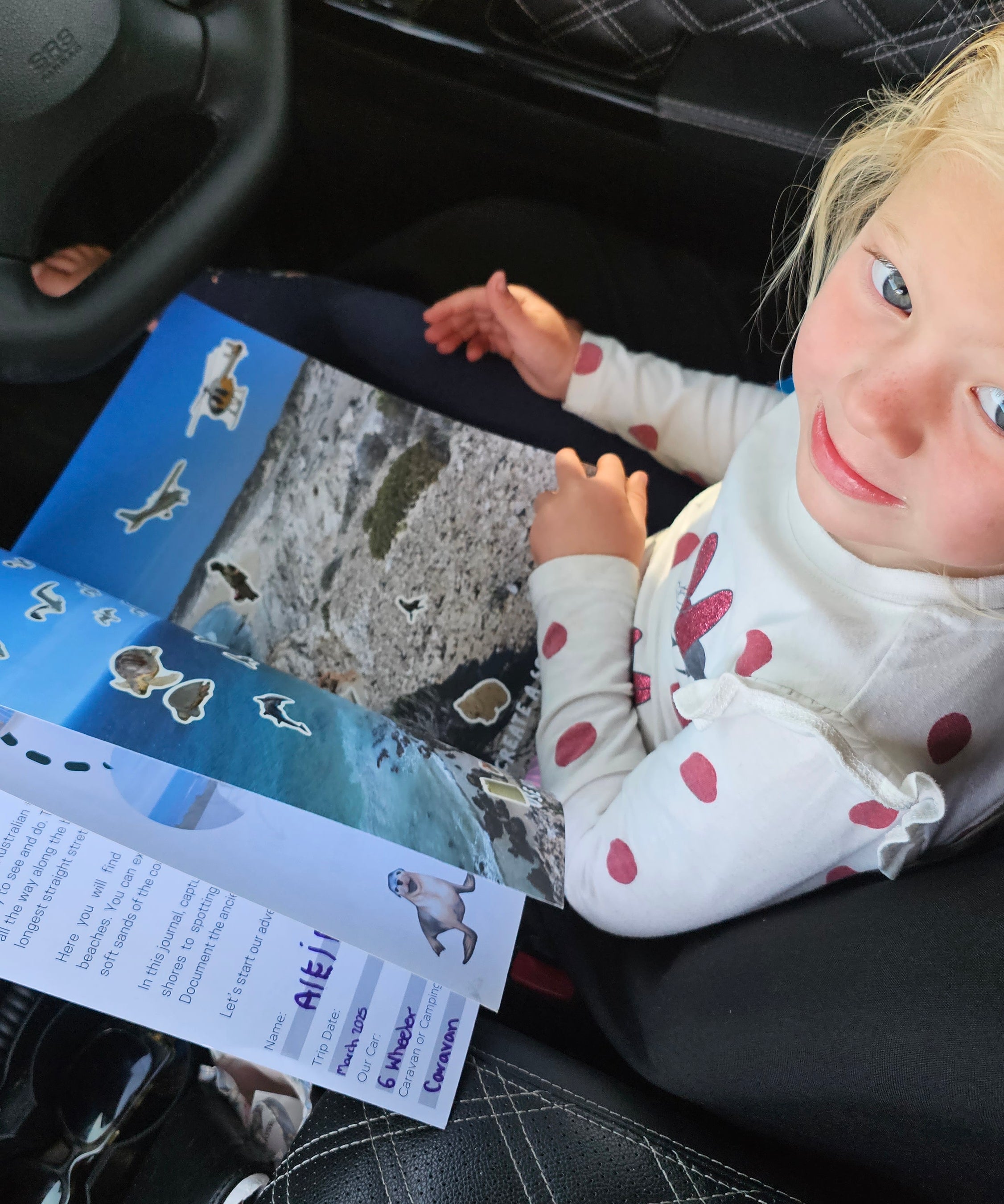 Child in a car seat with a south australian travel journal 