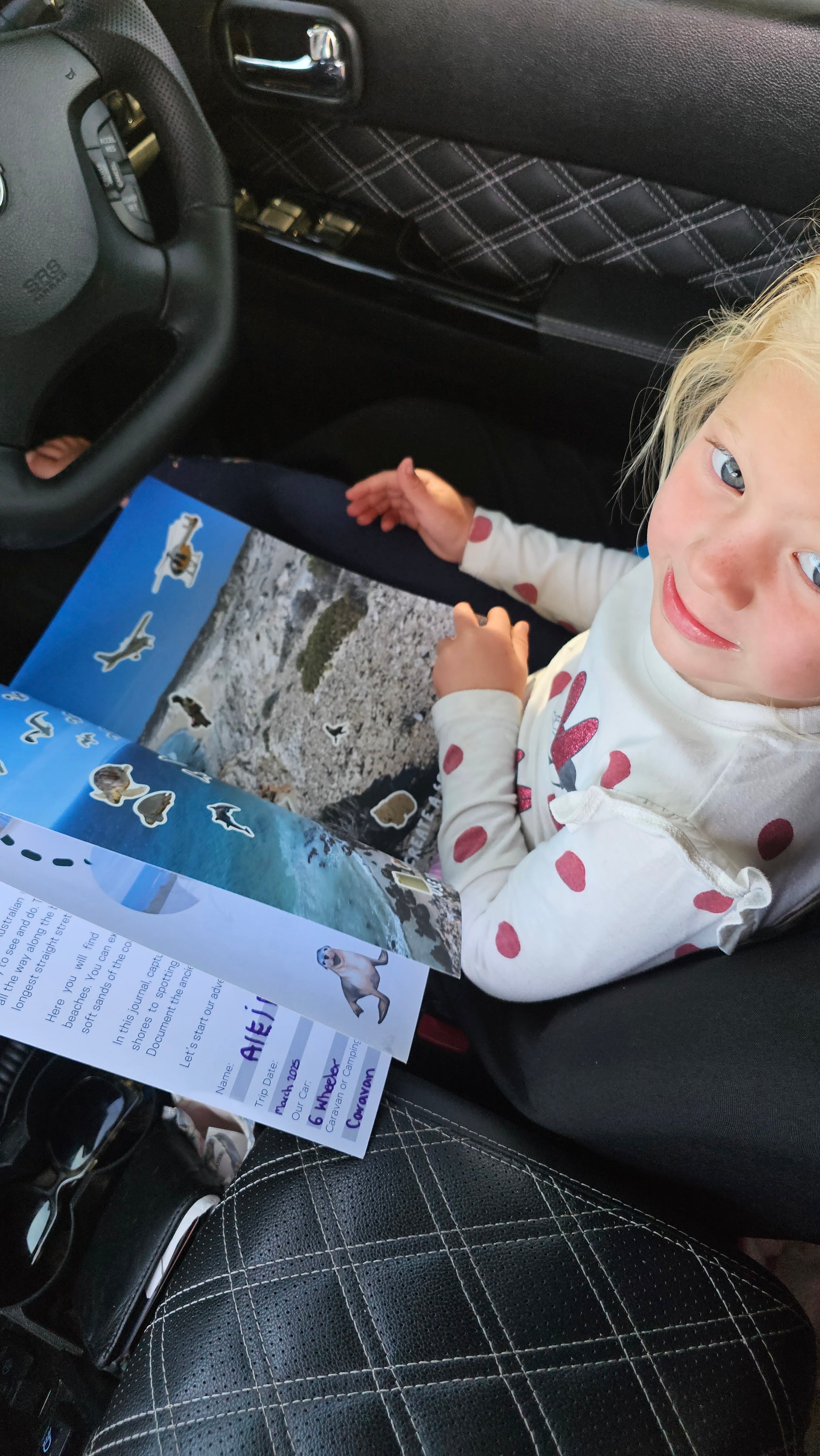 Child in a car seat with a south australian travel journal 