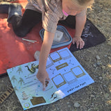 Child playing with a dinosaur travel journal outdoors on a sunny day