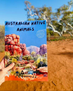 Australian Native animal book being held up in desert background