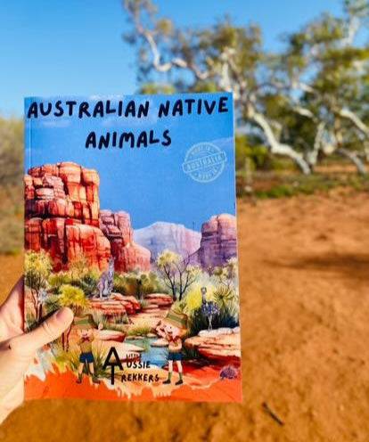 Australian Native animal book being held up in desert background