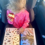 Child in car seat with stickers in an australian travel journal titled the kimberley