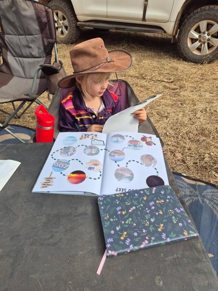 Australian travel journal working on  outdoors with a vehicle in the background