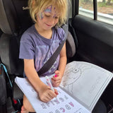 Child sitting in a car seat with a australian road trip coloring book and crayon