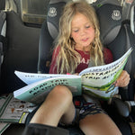 Child  completing an australian road trip activity in a car seat with road trip activities.