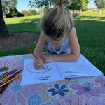 Child coloring outdoors in an australian native animals activity book