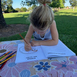 Child coloring outdoors in an australian native animals activity book