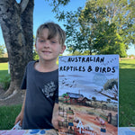 Child holding up australian reptiles and birds activity book