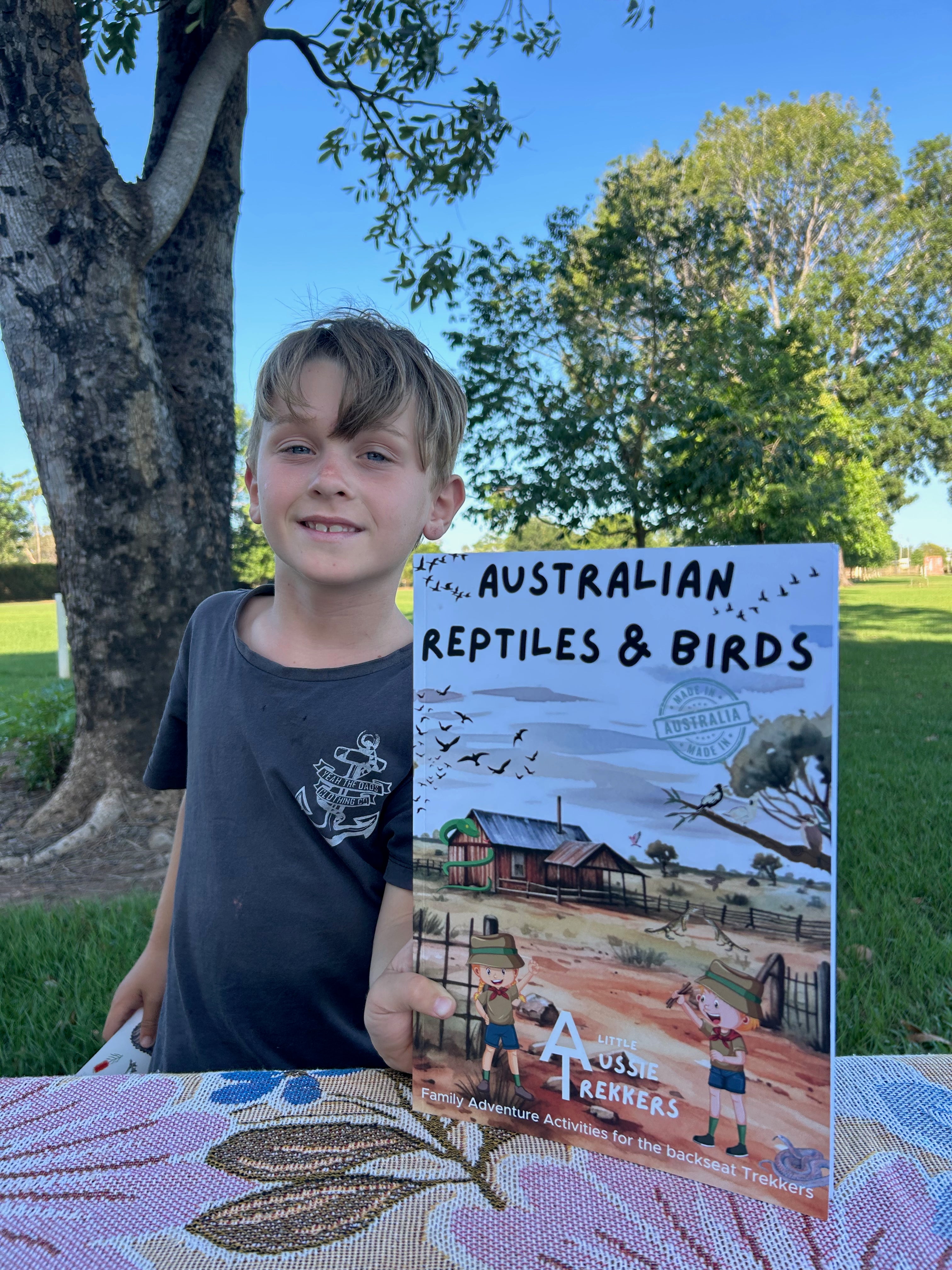 Child holding up australian reptiles and birds activity book