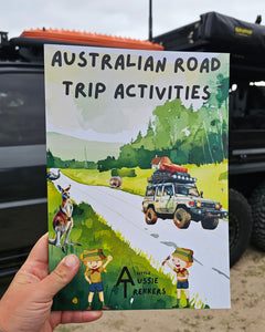 Australian Road Trip Activitys book held up in front of car